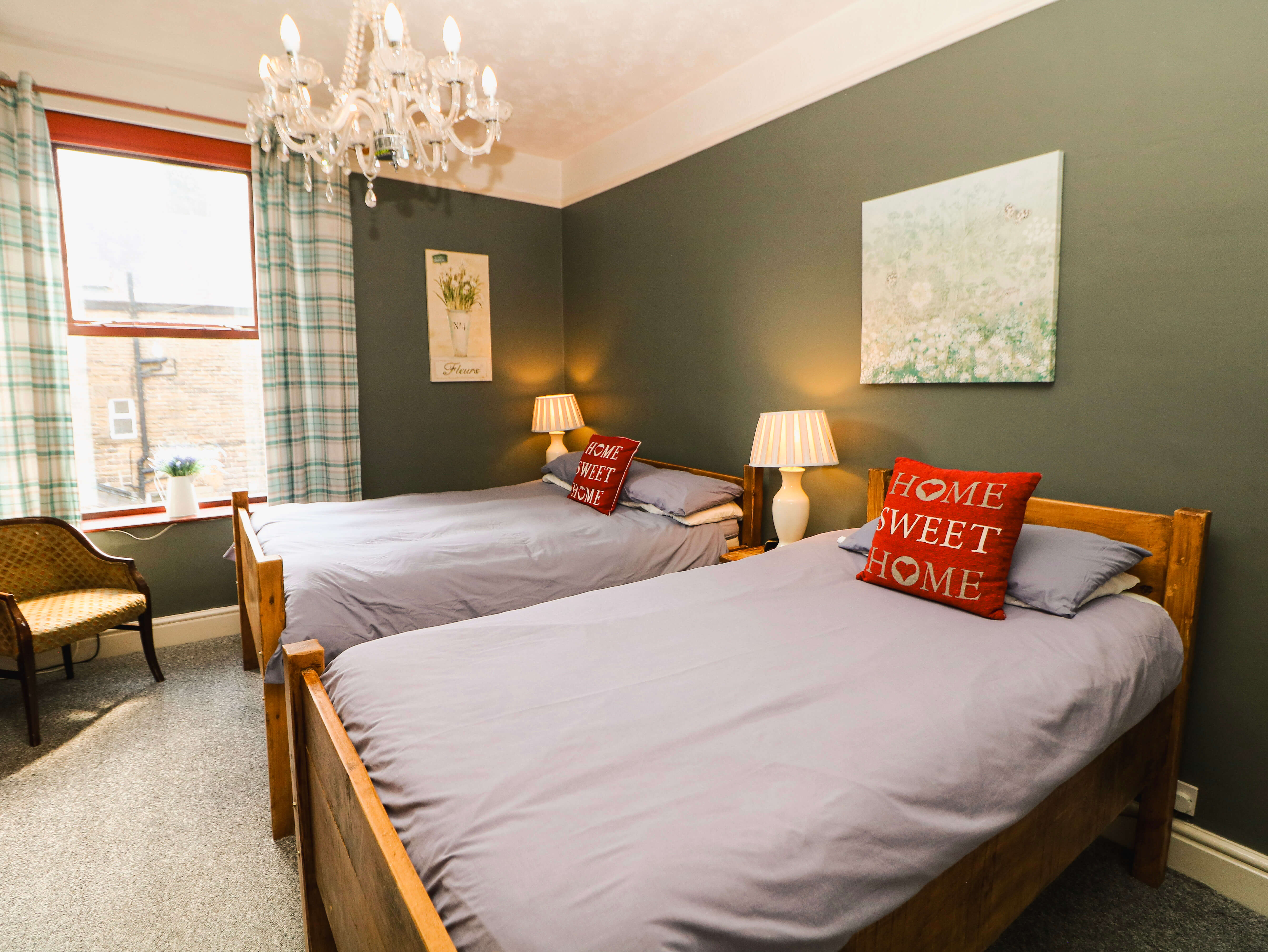 Room 1 at Compton Guest House in Buxton with double and single beds, grey walls and chandelier
